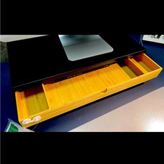 an open drawer on top of a desk with a mouse pad and keyboard in it