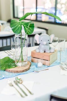 an elephant figurine sitting on top of a wooden box next to a plant