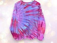 This is a soft, comfy long sleeved tee, hand dyed by me in shades of soft purple, strawberry pink, periwinkle, and ice blue.  This is a quality tee, very soft, medium to heavy weight, with a relaxed fit.  MEASUREMENTS; Chest: 50 inches Length, underarm to hem: 19 inches CARE AND MATERIALS: 100% cotton. Machine wash cool, tumble dry low. I have put this shirt through three rinse cycles and a warm water wash, but you may wish to wash it alone the first time just to be on the safe side. Purple Strawberry, Strawberry Pink, Tie Dye Long Sleeve, Soft Purple, Ice Blue, Heavy Weight, Warm Water, Hand Dyeing