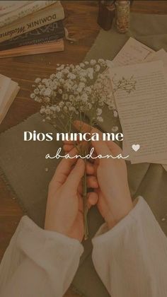 a person holding flowers with the words dios nunca me above them and an open book