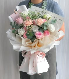 a person holding a bouquet of flowers and a card