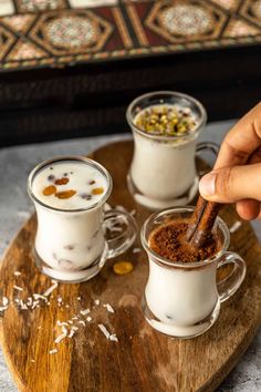 two cups filled with different kinds of food on top of a wooden tray next to each other