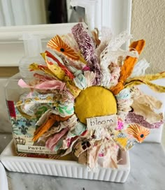 a white plate topped with lots of different types of fabric and paper mache flowers