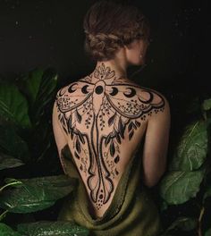 the back of a woman's body covered in tattoos