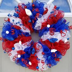 a red, white and blue mesh wreath on a door