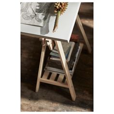 an easel with flowers sitting on top of it