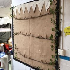 a bulletin board with ivy growing on it's sides and hanging from the wall