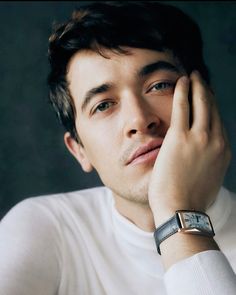 a close up of a person with a watch on his wrist and wearing a white shirt