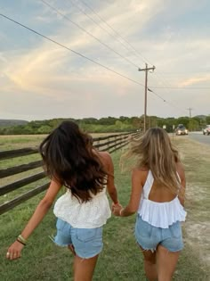 two girls walking down the road holding hands