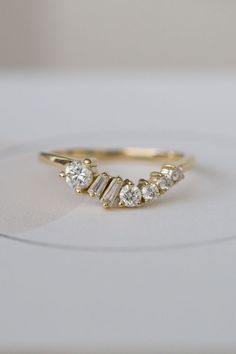 a yellow gold ring with three diamonds on the top and one diamond in the middle