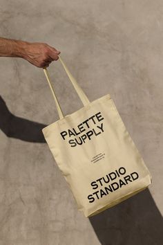 a person holding a bag that says palette supply and studio standard on the side