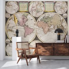 an old world map on the wall in a living room with leather chairs and suitcases