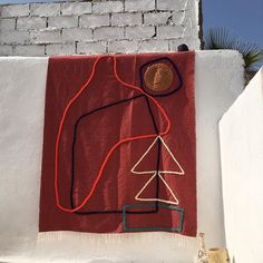 a red towel hanging on the side of a white building with a drawing of a man