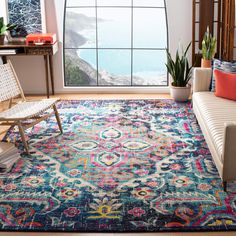 a living room with a large window and colorful rug