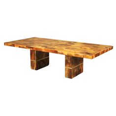 a wooden table sitting on top of a white floor next to a brick wall in the shape of a rectangle