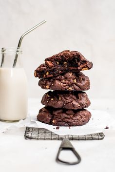 chocolate cookies stacked on top of each other next to a glass of milk