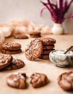 chocolate cookies are arranged on a table next to a bowl