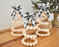 two wooden bracelets with black and white bows are sitting on a table next to a potted plant