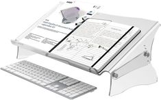 a computer keyboard sitting on top of a desk next to a binder and paper