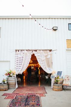 an outdoor wedding venue with white curtains and lights