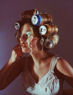 a woman with rollers on her head and some hair dryers in her hair