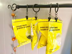 two bags of food hanging from hooks on a wall