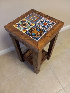 a small wooden table with colorful tiles on it