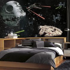 a bedroom with star wars wallpaper and bedding