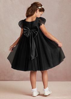 Kalio is our adorable tulle and matte satin flower girl dress. She features a square neckline that is framed with charming short flutter sleeves. She has an empire waist that offers comfort and ease of movement. The flowy A-line skirt adds whimsy while the removable bow gives this dress versatility. This dress is not only perfect for a flower girl at a wedding but also versatile enough for other special occasions. Flower Girl Black Dress, Black And White Flower Girl Dress, Black Flower Girl, Black Flower Girl Dress, Dresses In Black, Satin Flower Girl Dress, Girls Black Dress, Infant Flower Girl Dress, Tulle Flower Girl