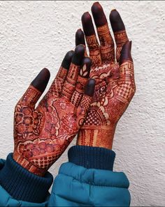 a woman's hands with henna tattoos on them