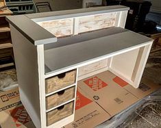 an unfinished desk with drawers on top of it