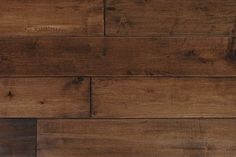 a close up view of a wood floor with dark brown stain on the planks