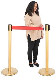 a woman is standing behind a red barrier