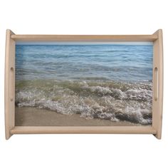 an ocean scene with waves coming in from the shore and sand on the beach below