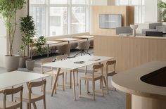 an empty office with desks, chairs and plants in the middle of the room