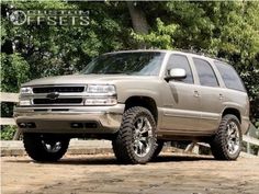 a silver truck parked on top of a dirt road