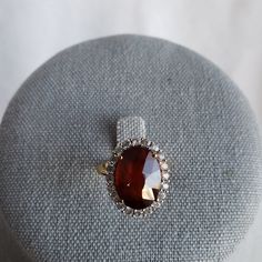 Gemporia Hessonite (Red) Garnet Ring. 8.42ctw Oval (14x10), Basket Setting. 20 Round White Topaz Stones In A Halo Around Garnet. Ring Is Yellow Gold Over 925 Silver, Weighs 4.3g. Size 6. This Is A Stunner! Classic Oval Gemstones With Halo Setting, Exquisite Oval Gemstones For Formal Occasions, Exquisite Oval Gemstones For Formal Events, Elegant Oval Cabochon Wedding Gemstones, Exquisite Oval Gemstones With Accents, Oval Gemstones With Halo Setting For Formal Occasions, Oval Center Stone Gemstones For Formal Occasions, Elegant Oval Gemstones With Accents, Formal Ruby Ring With Gemstone Accents