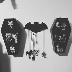 three black and white clocks are hanging on the wall next to each other with pop figures attached to them