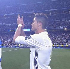 two soccer players are applauding each other at the end of a game in front of an audience