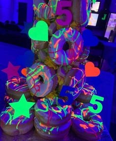 there is a cake made to look like doughnuts with neon lights on them