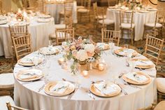 the table is set with white linens, gold chargers and silverware for an elegant wedding reception