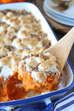 a casserole dish with marshmallow topping and a wooden spoon in it