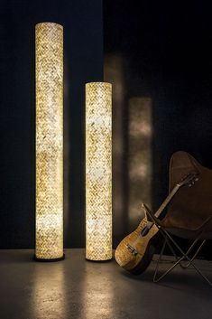 a guitar sitting next to two tall lamps