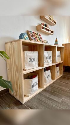 a wooden shelf filled with lots of bags and boxes next to a plant in a room