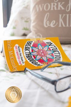 a pair of reading glasses sitting on top of a bed next to a book and eyeglasses