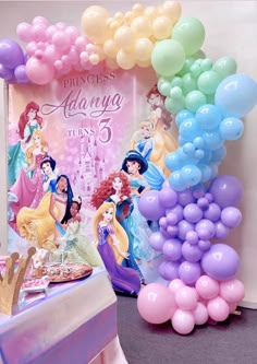 there is a table with balloons and princesses on it