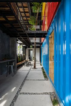 the walkway is lined with brightly colored shipping containers and tables on either side of it