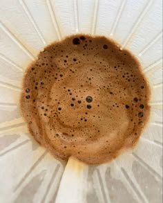 an upside down view of a coffee cup on a white paper plate with black dots