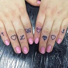 two fingers with tattoos on them, one has a bow and the other has hearts