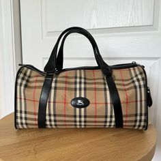 Vintage Burberry’s Bag In The Classic Plaid Pattern! Good Condition, Has Some Staining On The Bottom Of The Bag And Signs Of Wear Throughout As Shown. The Integrity Of The Bag Is Not Affected And Has Tons Of Life Left! Zip Closure Side Pocket With Zip Closure Canvas Body, Leather Straps Vintage Burberry, Plaid Print, Burberry Bag, Side Pocket, Plaid Pattern, Black And Tan, Bags Handbags, Leather Straps, Duffle Bag